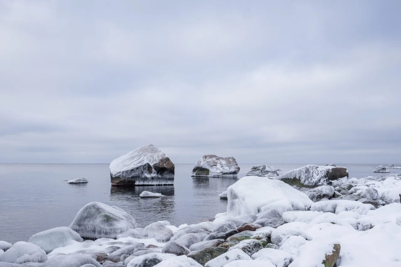 Kivinen ranta talvella iltavalossa.