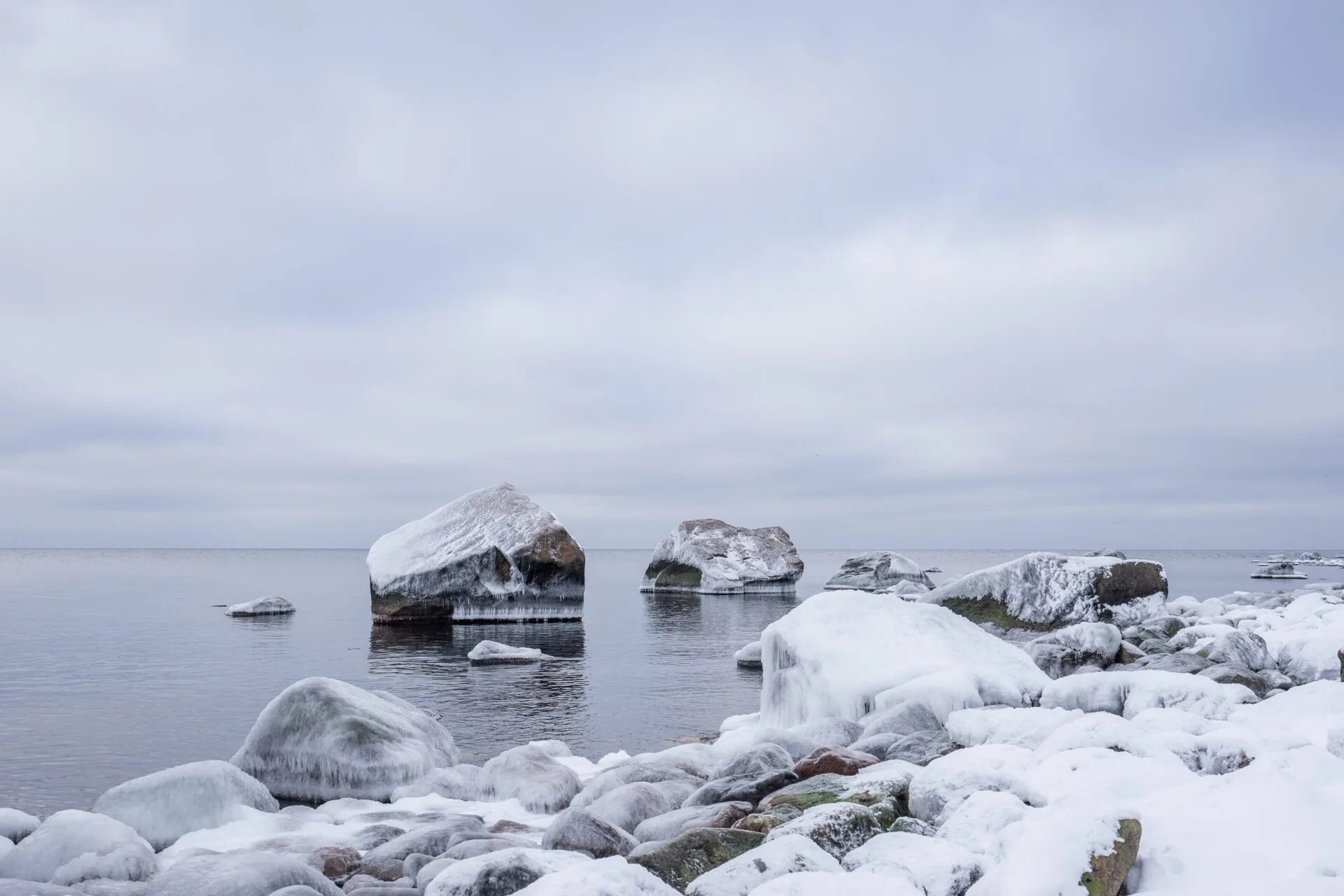 Kivinen ranta talvella iltavalossa.